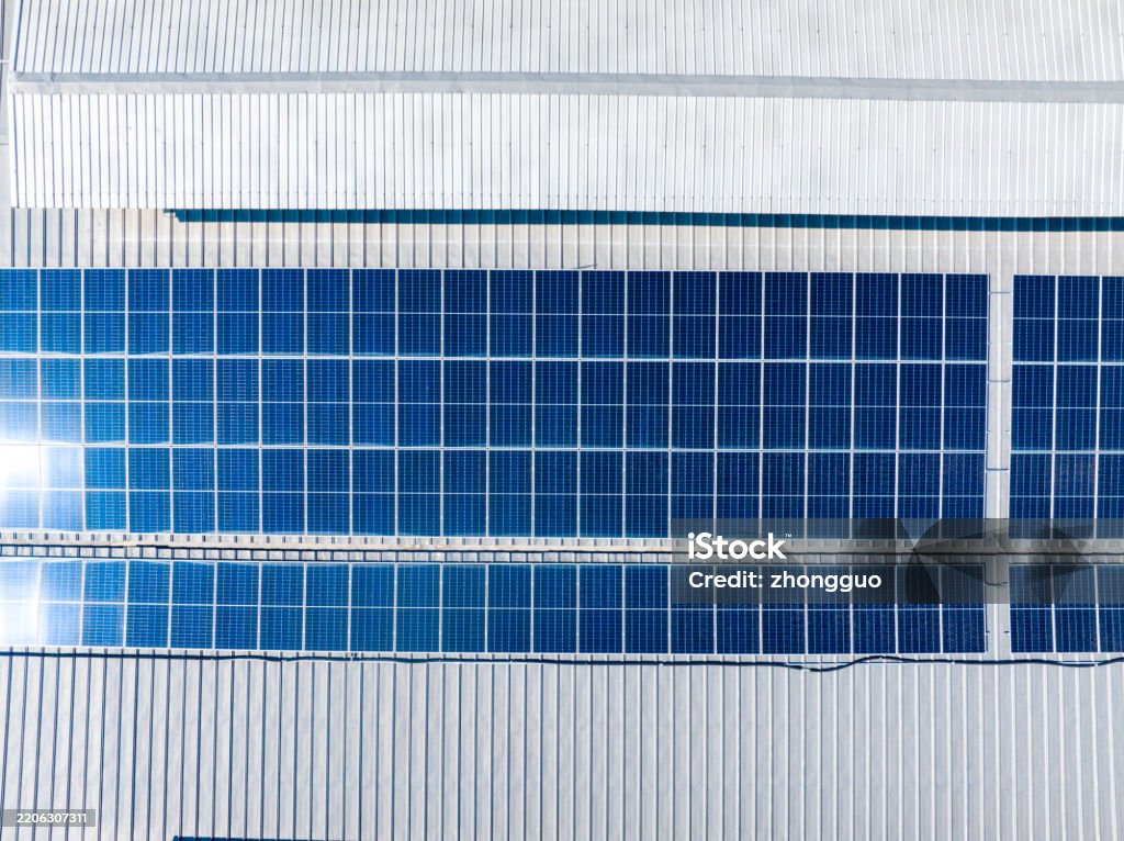 Aerial view of solar panels on factory roof.